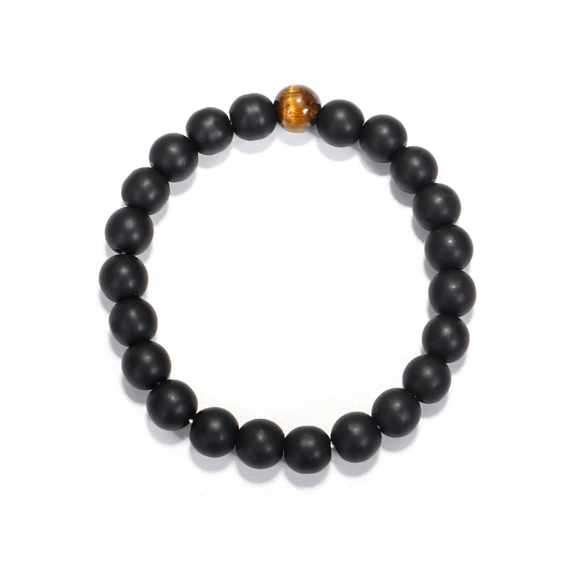 Black beaded bracelet with a single brown bead on a white background