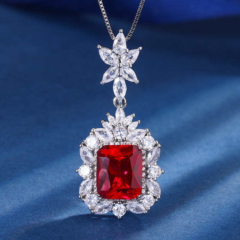 Diamond and red gemstone pendant on a blue fabric background
