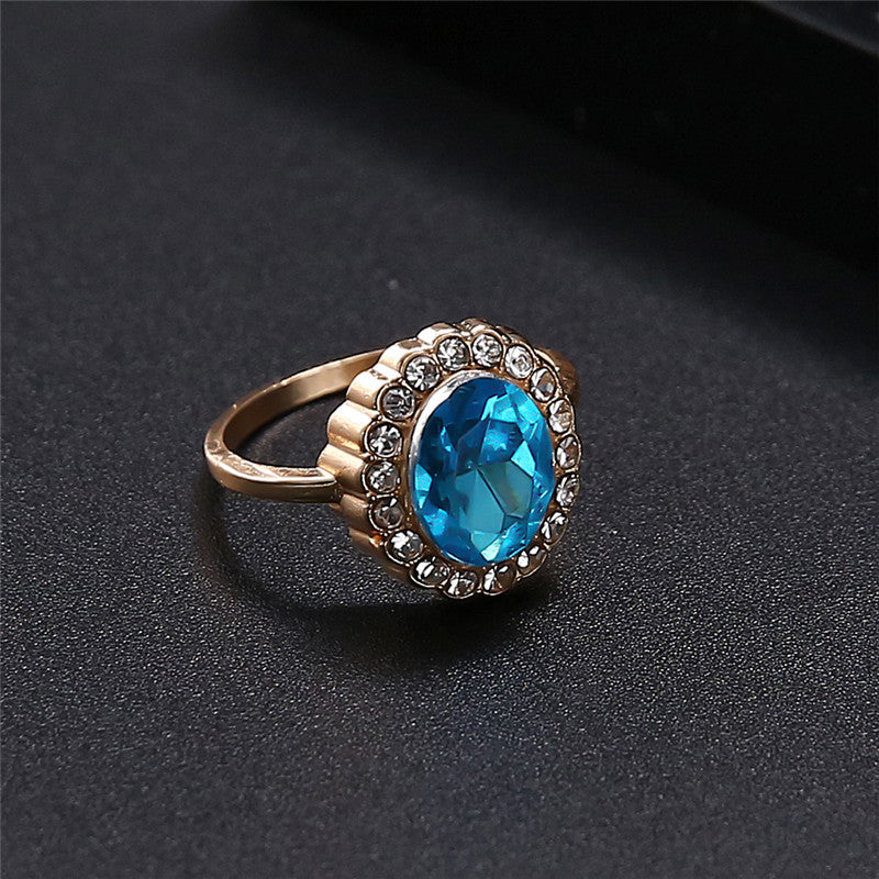 Gold ring with a blue gemstone on a dark background