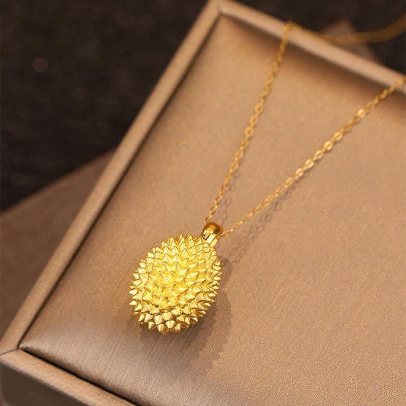 Gold necklace with a textured pendant on a brown box