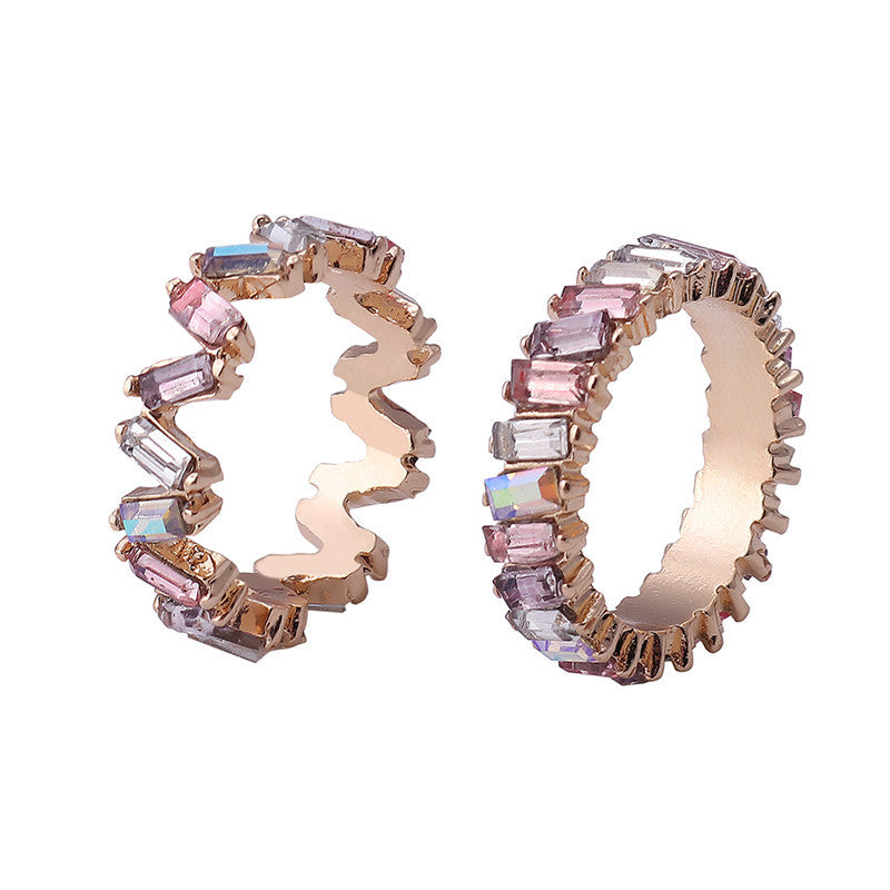 Pair of hoop earrings with pink and clear gemstones on a white background