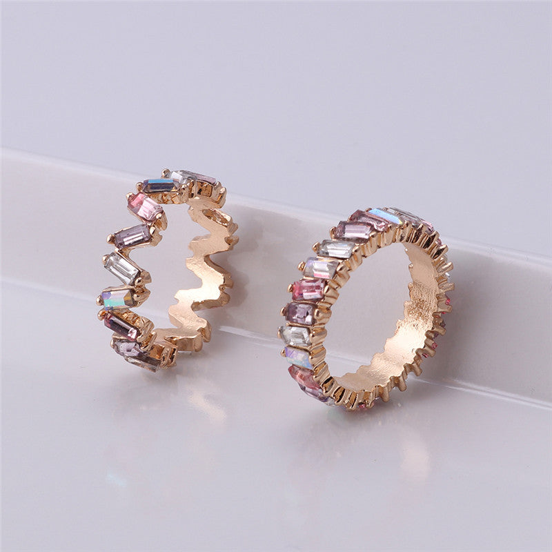 Gold hoop earrings with gemstones on a light gray background