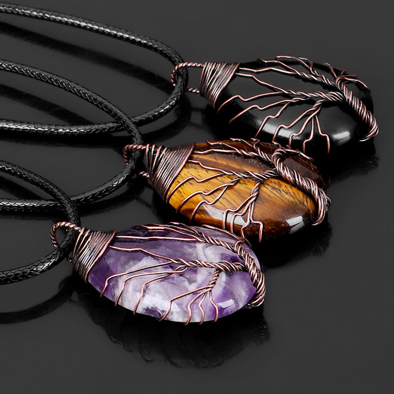 Three stone pendants on black cords with a dark background