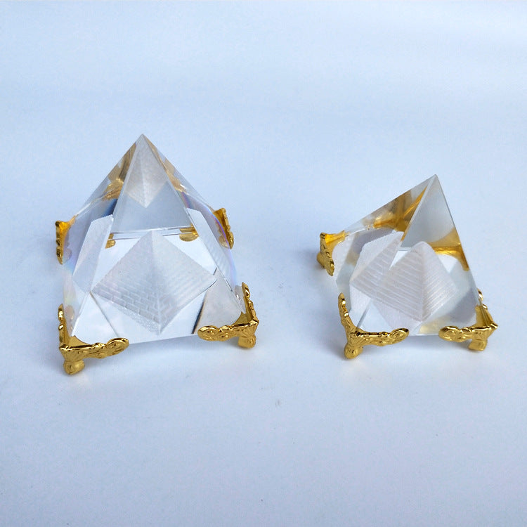 Two crystal pyramids with gold accents on a light blue background