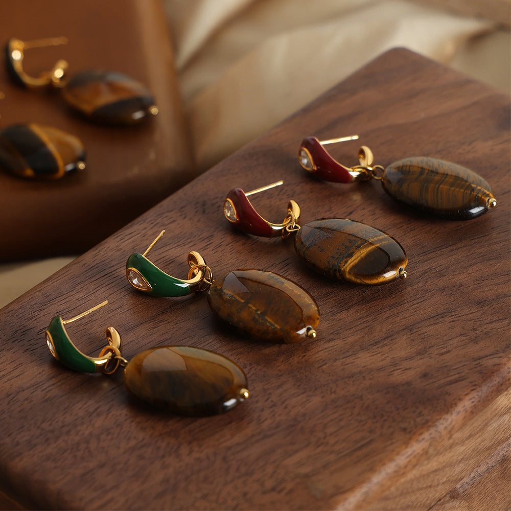 Pair of earrings with brown stones on a wooden surface