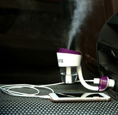 Car humidifier with steam coming out, placed on a car dashboard.