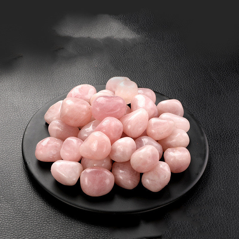 Pink stones on a black plate against a dark background