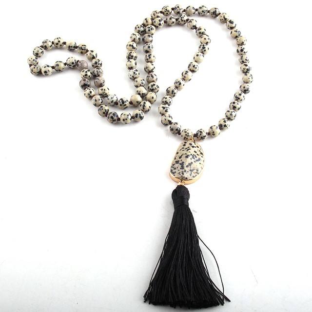 Necklace with dalmatian jasper beads and a black tassel on a white background
