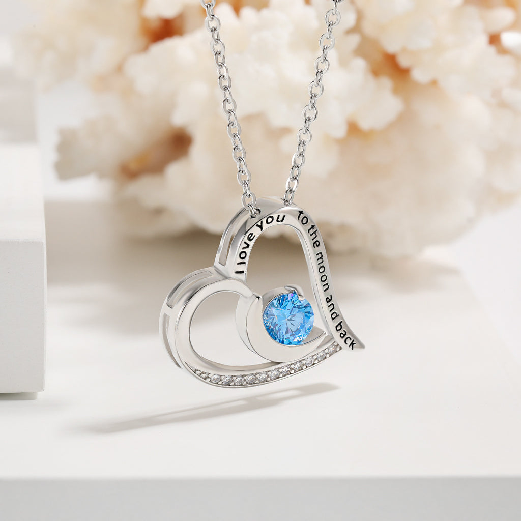 Silver heart-shaped necklace with a blue gemstone on a white background