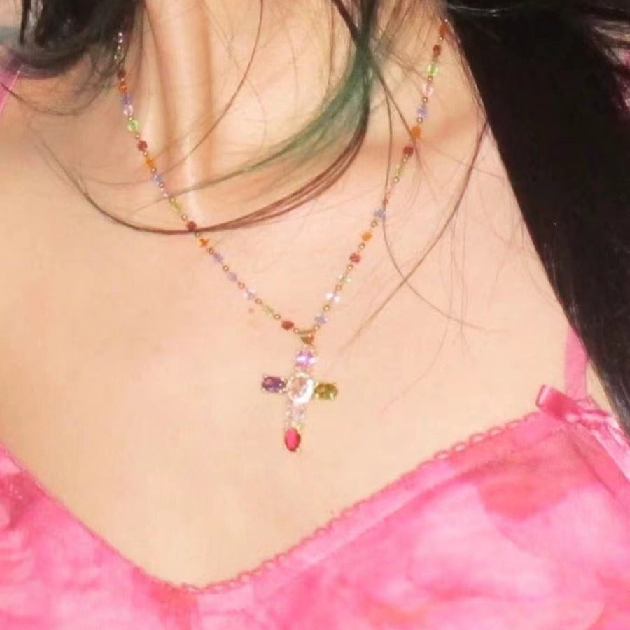 Close-up of a colorful beaded necklace on a person wearing a pink top.