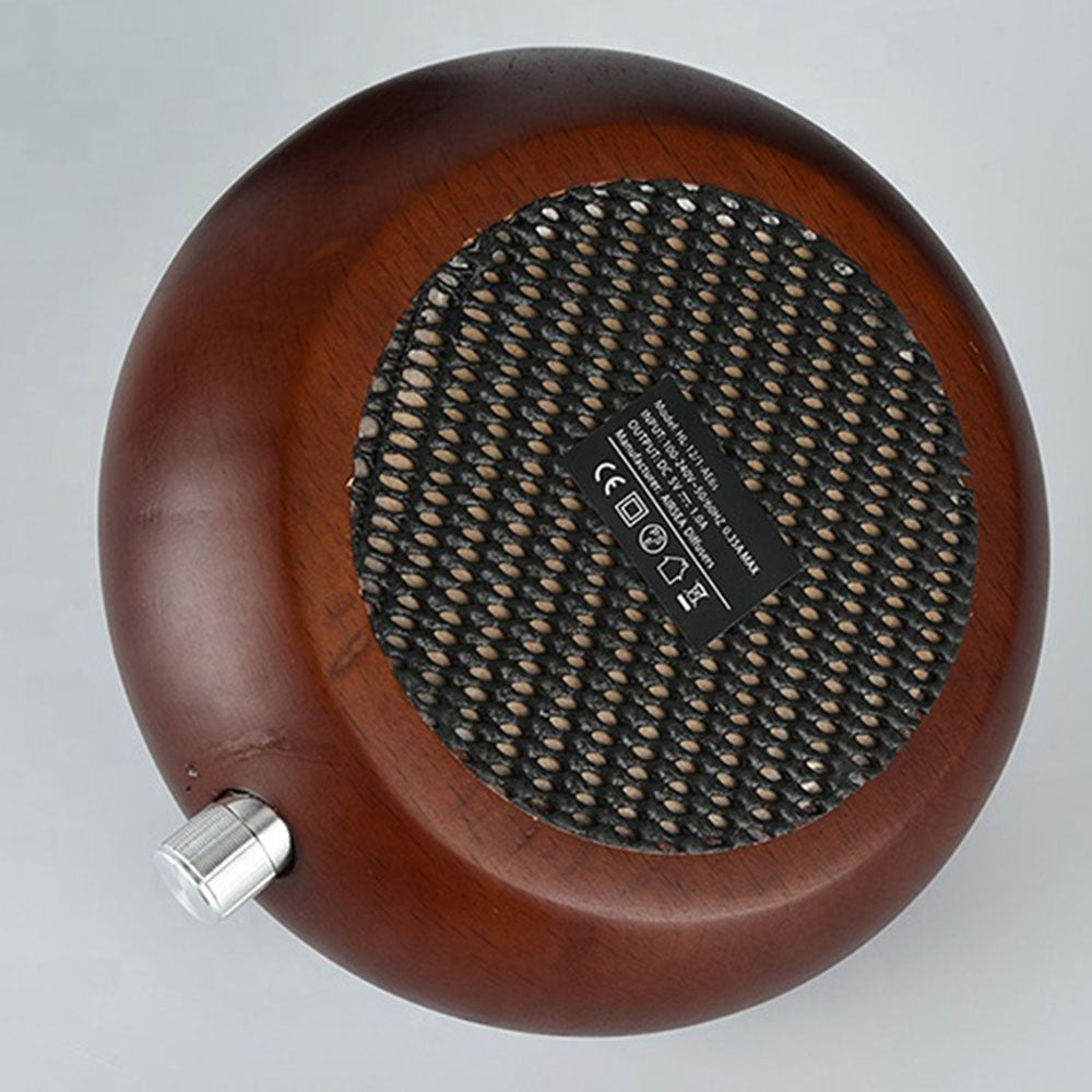 Wooden speaker with a metal knob on a gray background