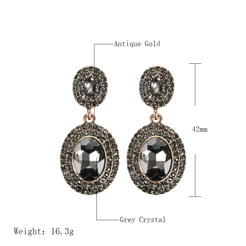 Pair of earrings with black crystals and gold accents, shown with measurements and weight on a white background.