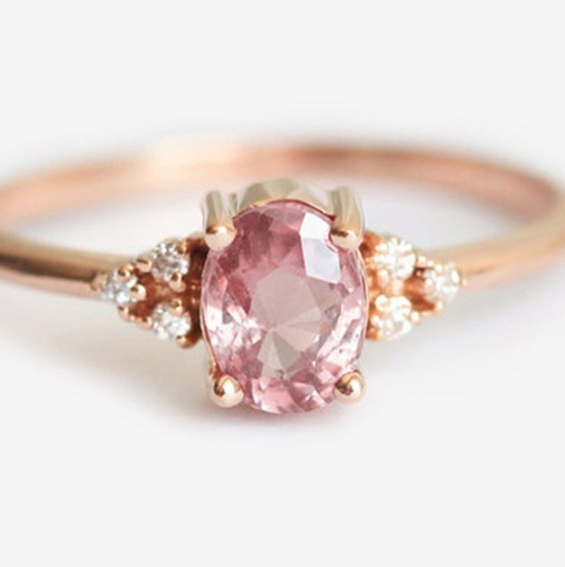 Rose gold ring with a pink gemstone on a white background