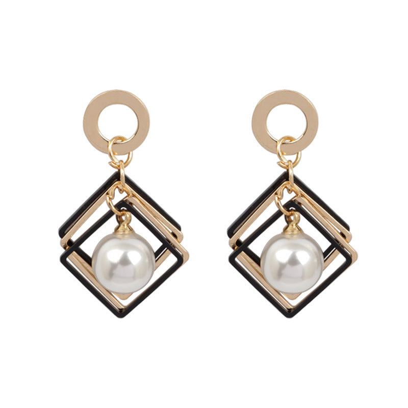 Pair of earrings with geometric design and pearl-like beads on a white background