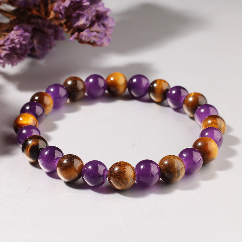 Multicolored beaded bracelet on a light background with purple flowers.