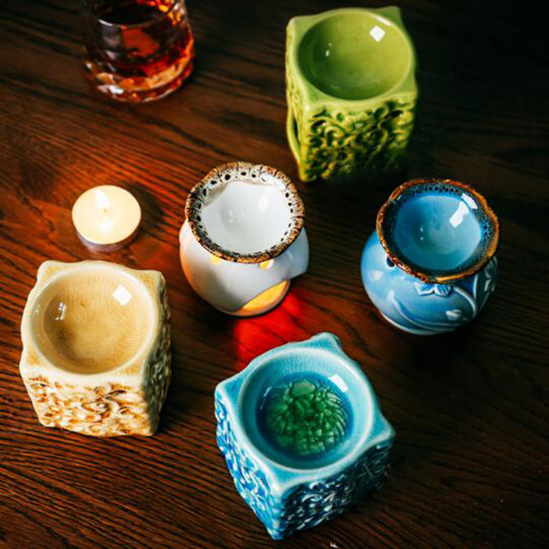 Set of small ceramic pots with different designs on a wooden surface.