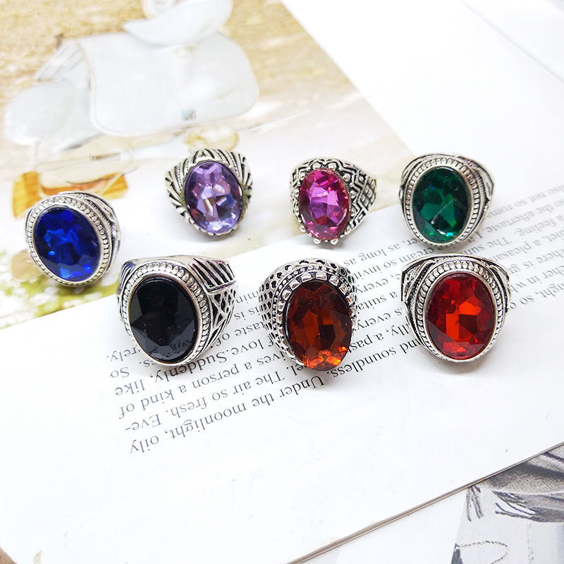 Set of colorful gemstone rings on a newspaper background