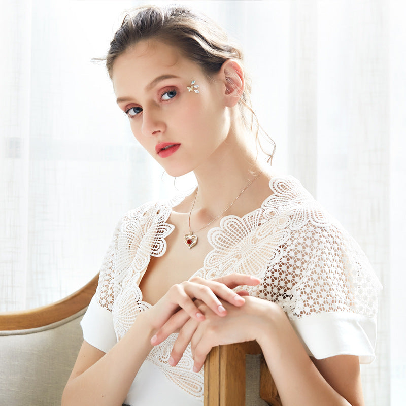 Woman wearing a white lace top with a neutral background