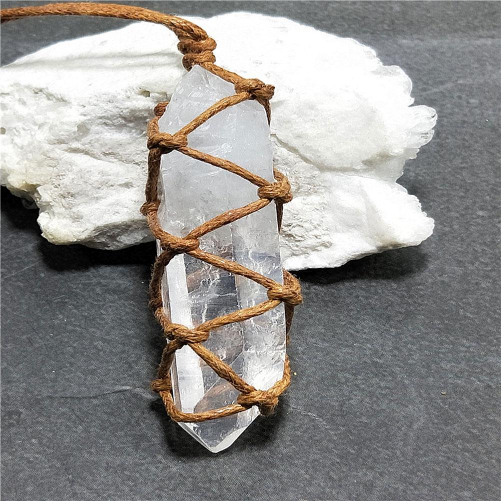 Crystal pendant with woven brown cord on a white crystal stone against a dark background