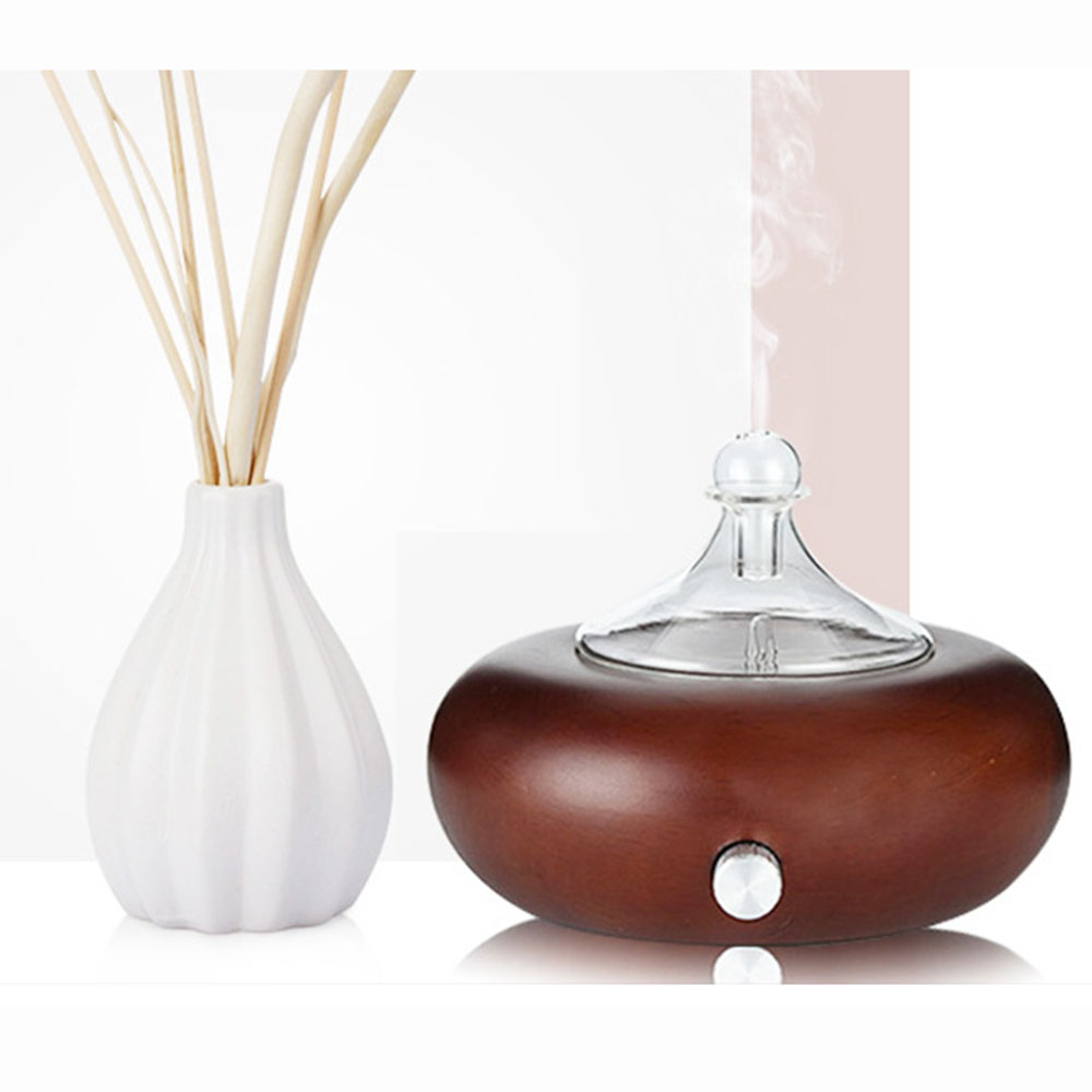 Diffuser with wooden base and white vase with sticks on a white background