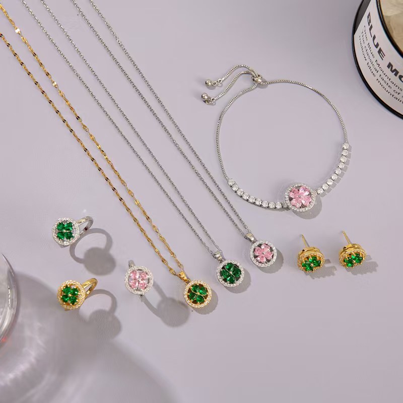 Jewelry set including necklaces, bracelets, and earrings with gemstones on a light background.