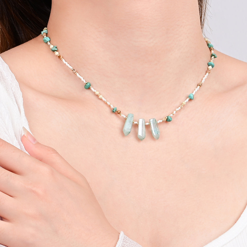 Necklace with beads on a person wearing a white top