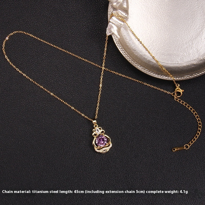 Gold necklace with a purple pendant on a black background