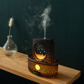 Decorative diffuser with smoking feature on a wooden surface against a dark background