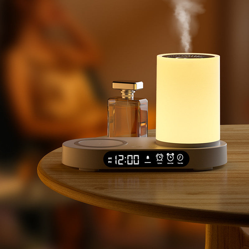 Tabletop device with digital clock, diffuser, and perfume bottle on a wooden surface.