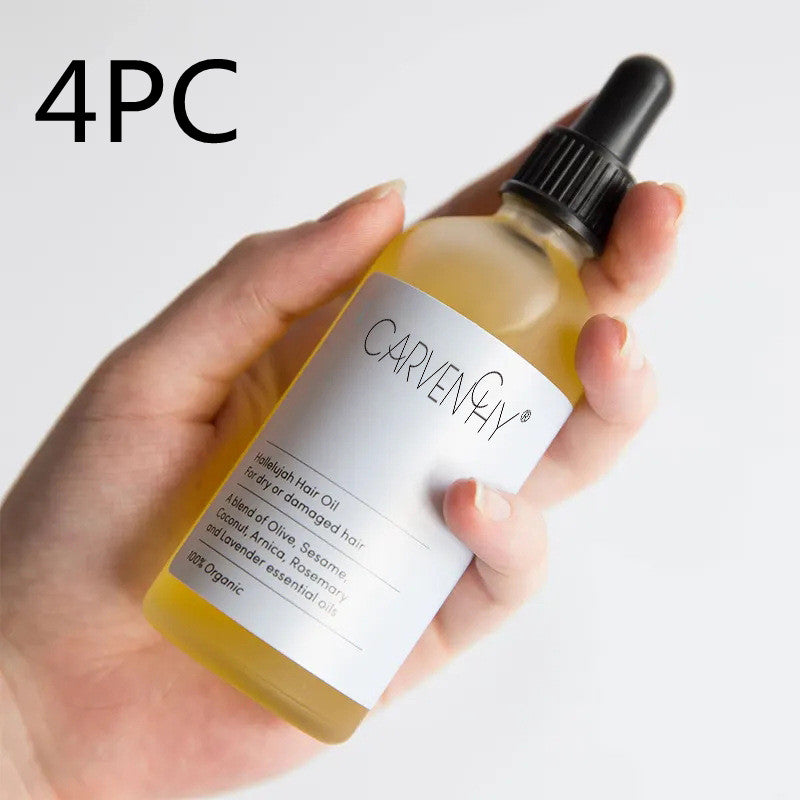 Hand holding a bottle of Carvenny hair oil with a dropper on a white background