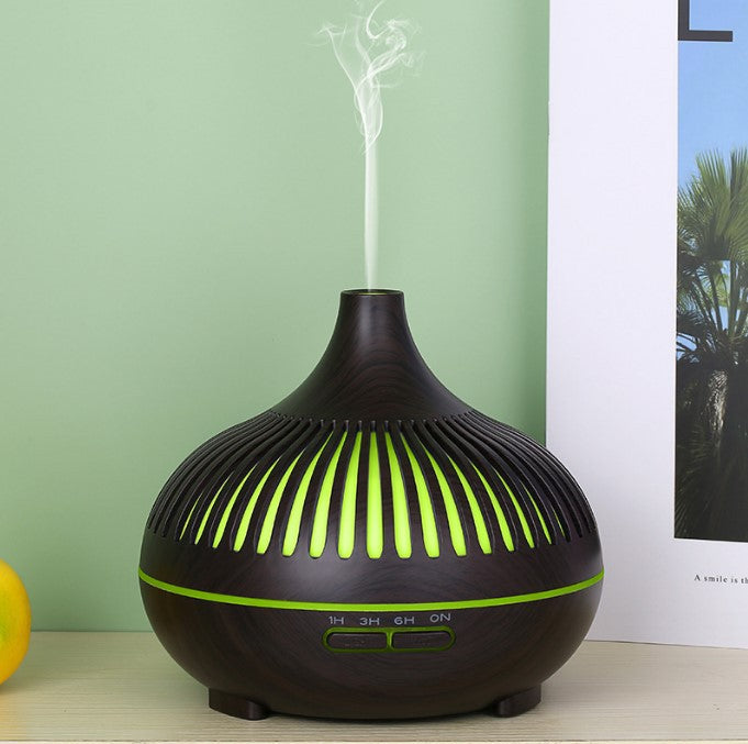 Black and green essential oil diffuser on a table with a light green wall in the background