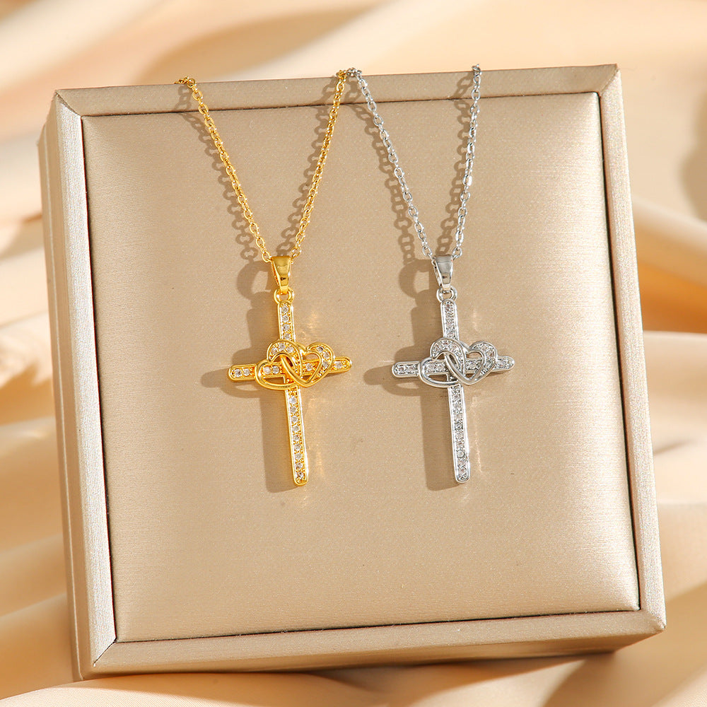 Two cross-shaped necklaces, one gold and one silver, on a beige box.
