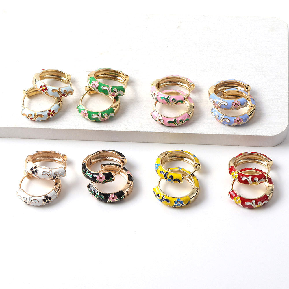 Set of colorful hoop earrings on a white surface