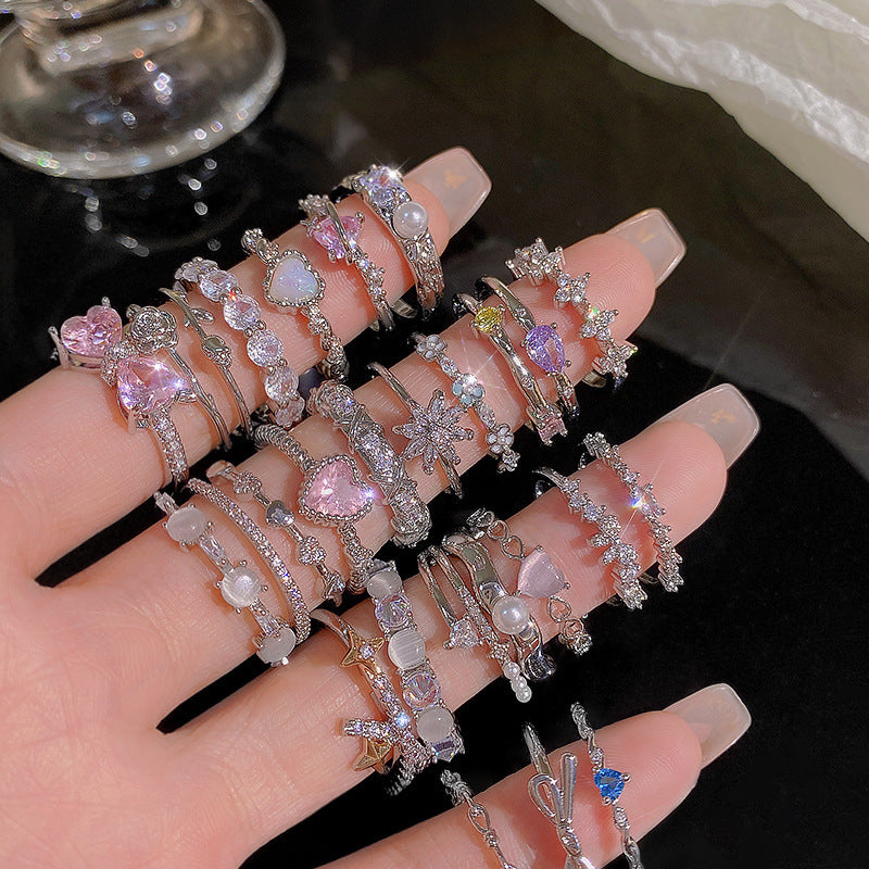 Multiple rings with various designs on a hand against a dark background