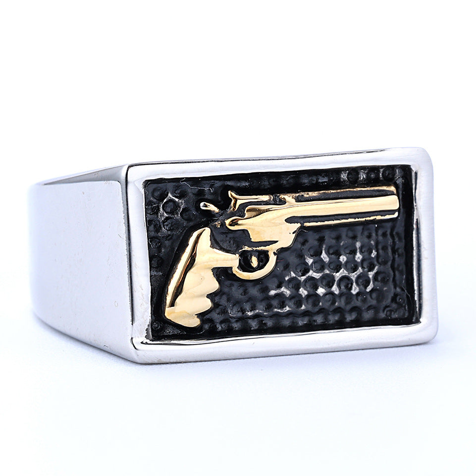 Ring with gold gun design on a black background