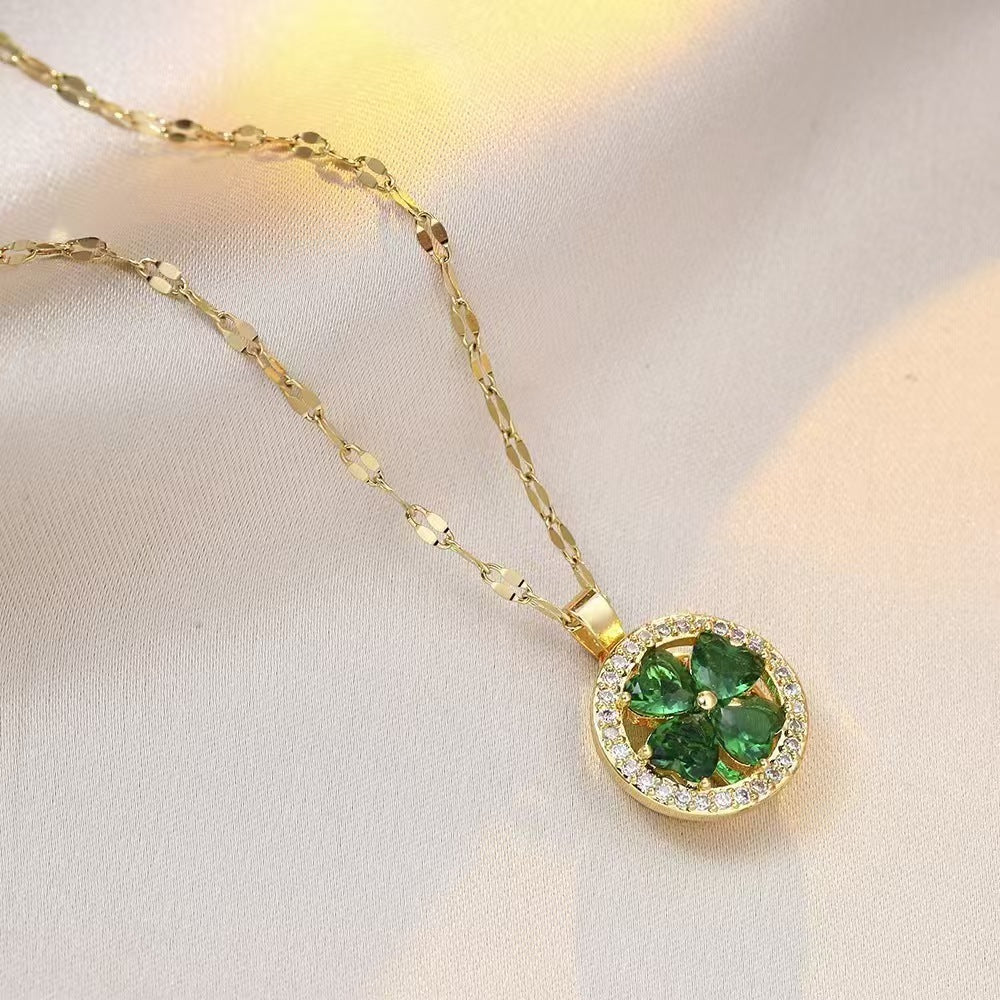 Gold necklace with a green gemstone pendant on a light background