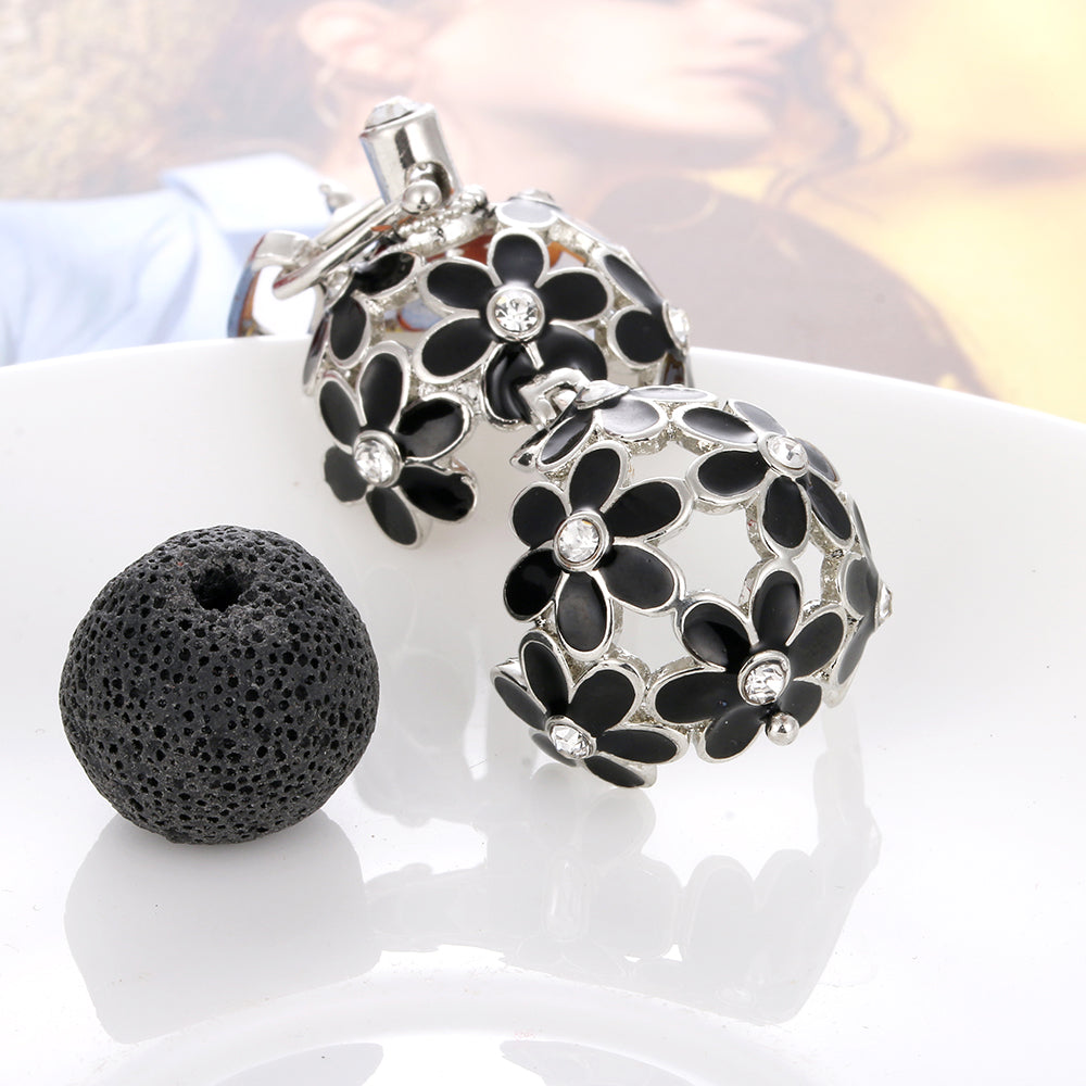 Black floral design diffuser with silver accents on a white surface