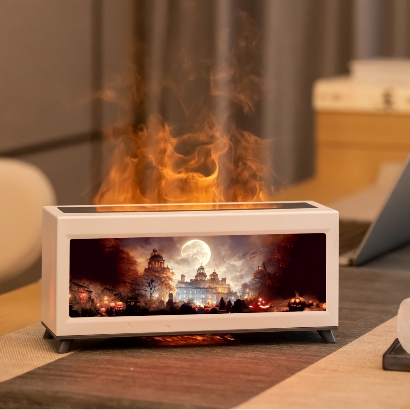 Tabletop fireplace with digital display showing a scenic scene on a wooden surface.