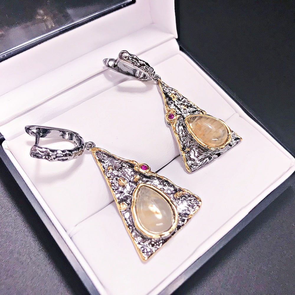 Two ornate pendants with gemstones in a jewelry box