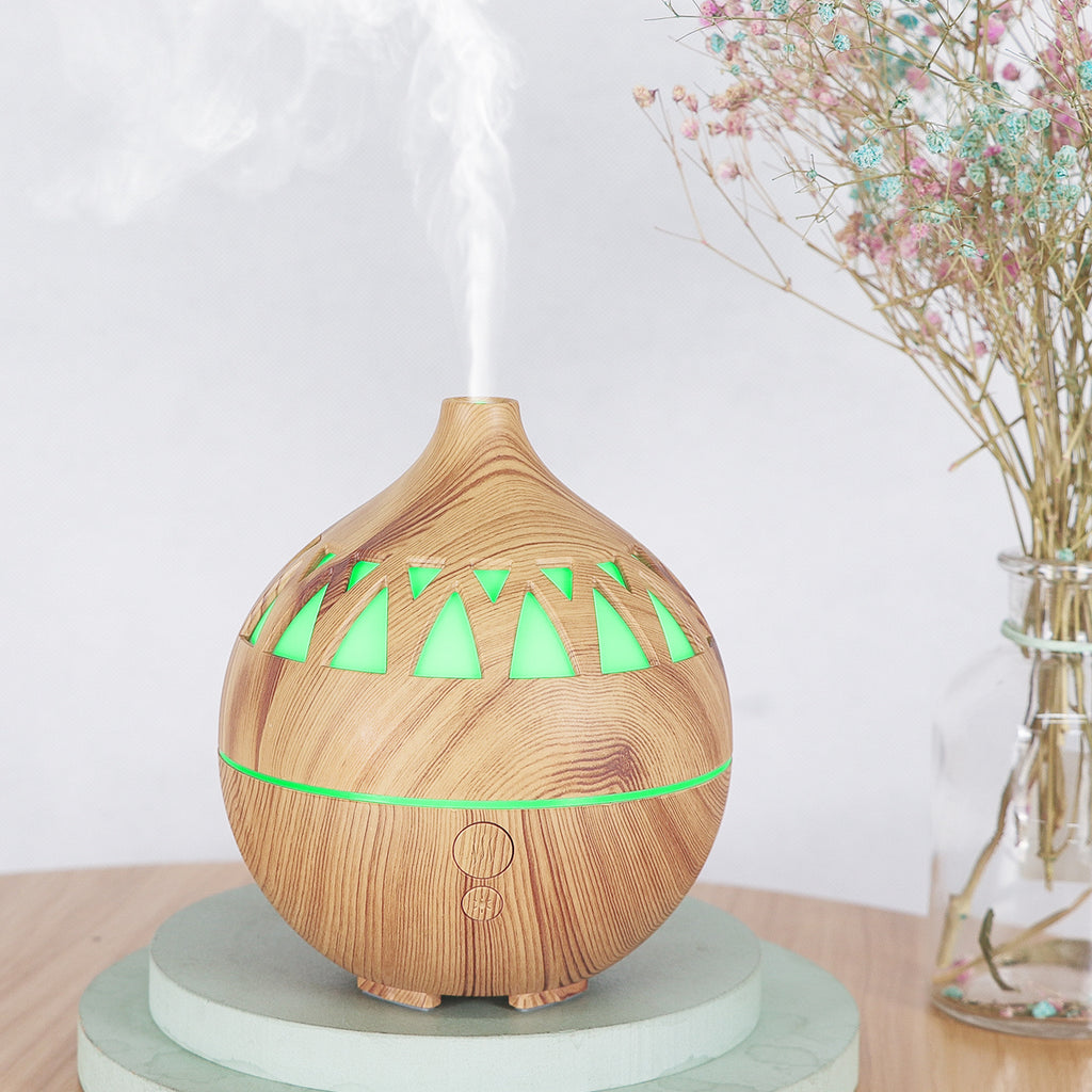 Wooden essential oil diffuser with green lights on a white background