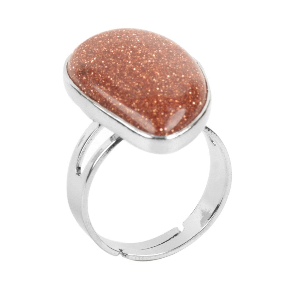 Ring with a brown stone and silver band on a white background