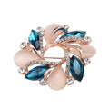Jewelry brooch with blue gemstones and rose gold accents on a white background