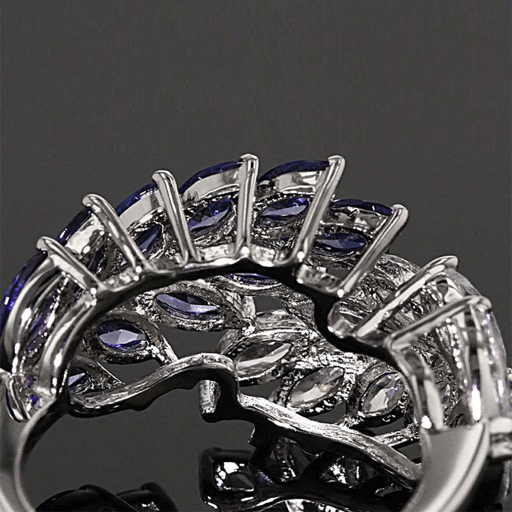 Close-up of a silver ring with purple gemstones on a dark background
