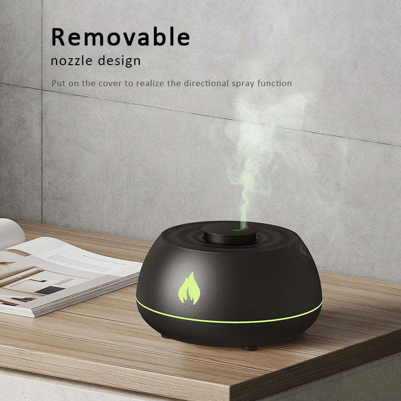 Black humidifier with steam on a wooden surface and gray wall background