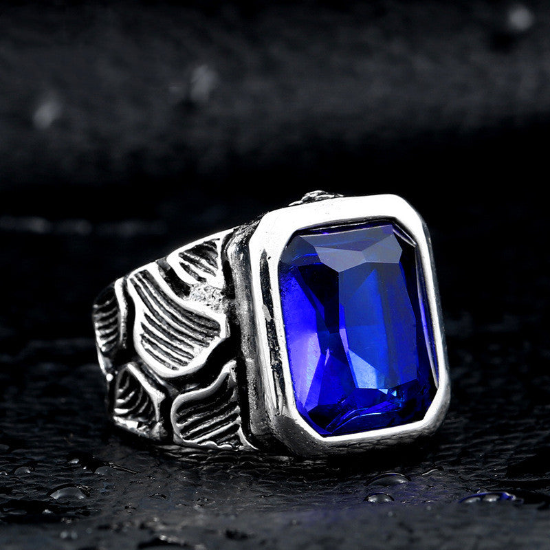 Silver ring with a blue gemstone on a dark textured background