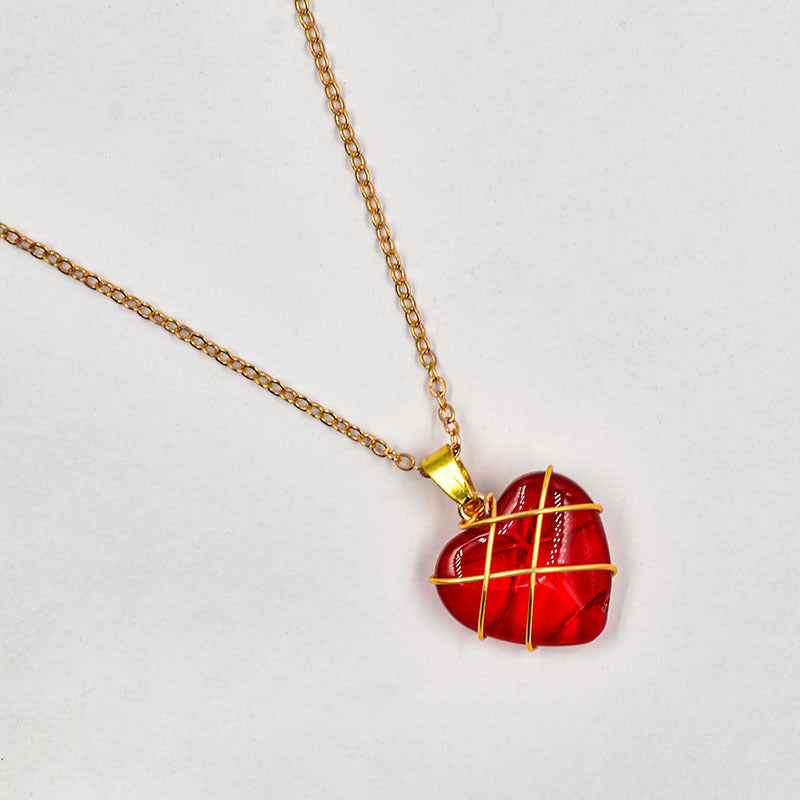Necklace with a red heart-shaped pendant on a light gray background