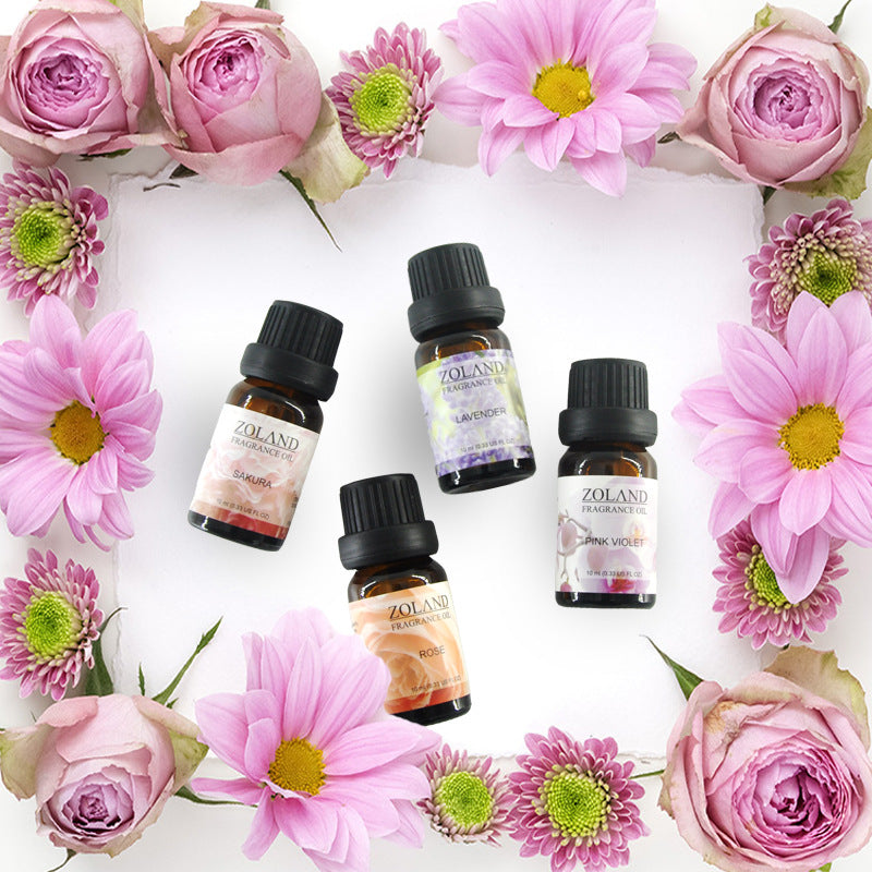 Zolando essential oil bottles surrounded by pink flowers on a white background