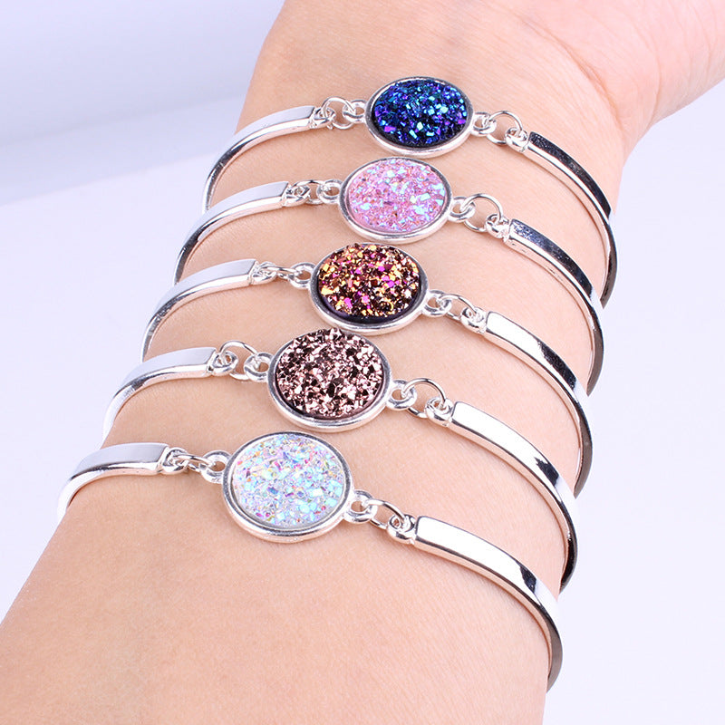 Set of silver bracelets with colorful glittery stones on a white background