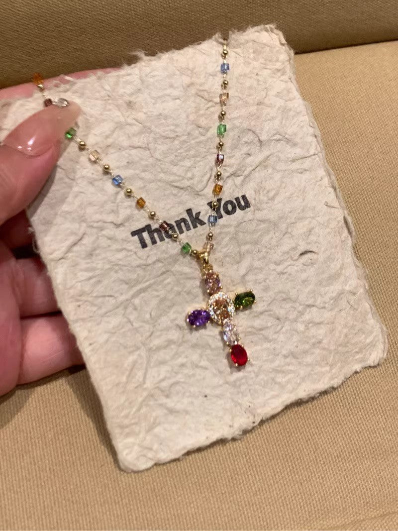 Colorful necklace with gemstones on a 'Thank You' card held by a hand.