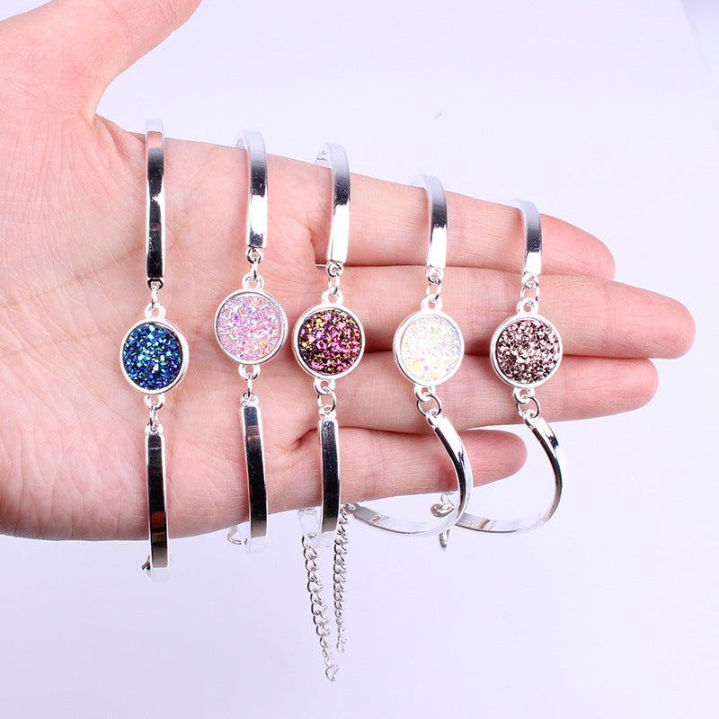 Set of silver bracelets with colorful gemstones on a hand against a white background